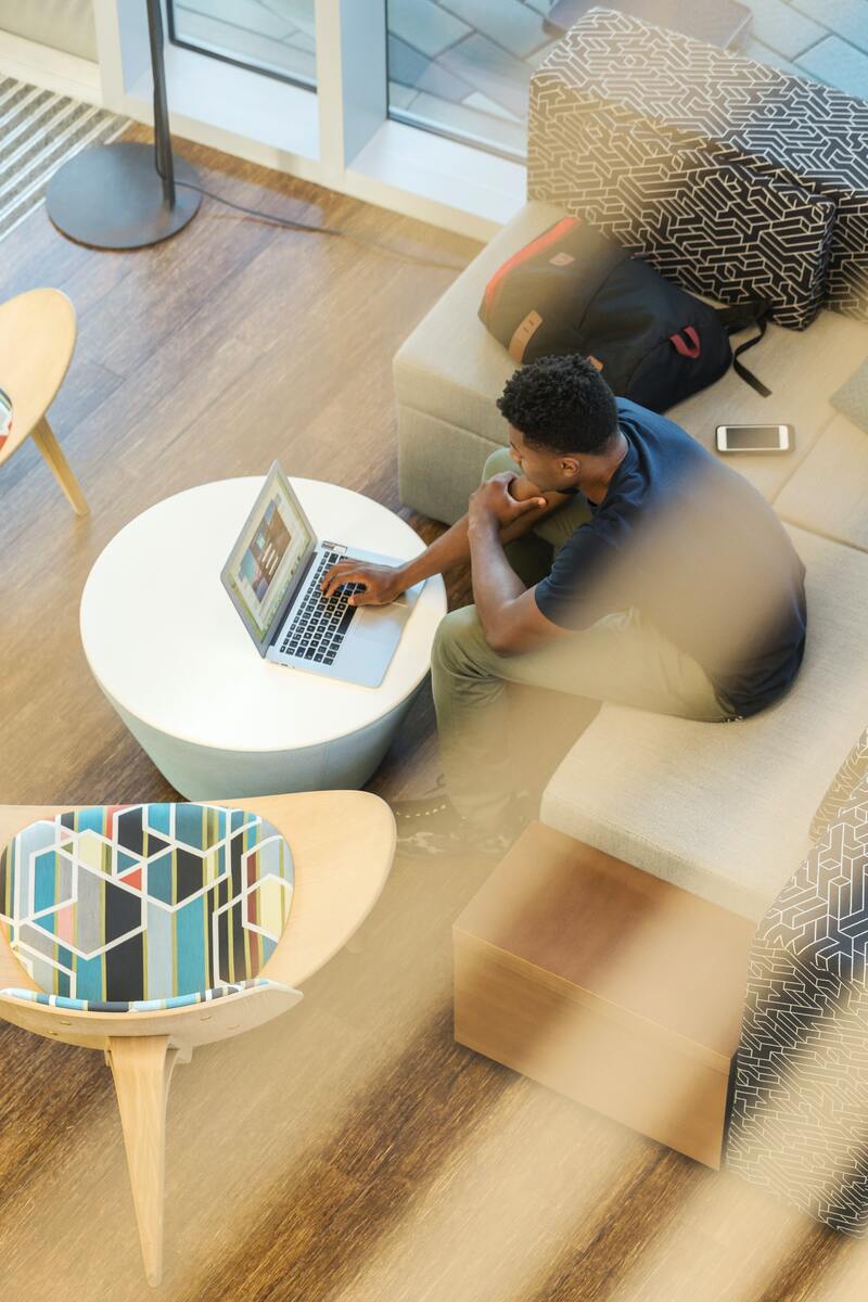 a man in an office typing on a lap top